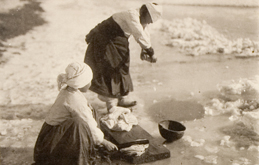 Women doing laundry through a hole in the ice in the winter