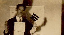 Yi Bongchang with written oath on chest and grenade in hands, in front of the Korean flag (December 13, 1931)